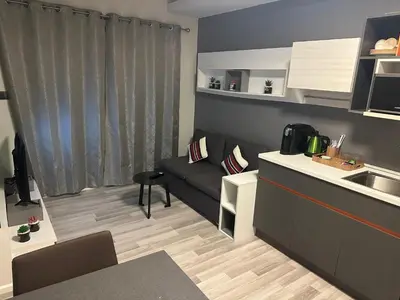 a small living room with a couch and a kitchen at Casa Bondia in Bangkok