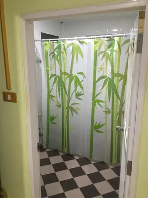 a bathroom with a shower curtain with bamboo at GreenRoom Guest House Very Close Bangkok Hospital in Thailand in Bangkok