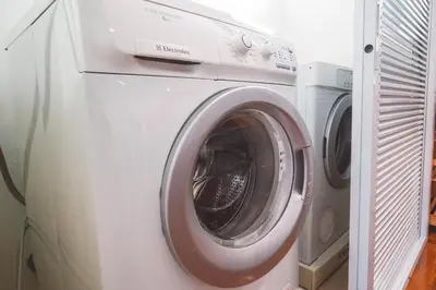 a white washing machine sitting next to two other machines at Chezmoi Bangkok Sukhumvit 26 Private Executive Residence 444 in Khlong Toei