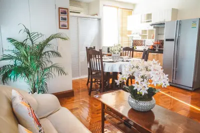 a living room with a table and a kitchen at Chezmoi Bangkok Sukhumvit 26 Private Executive Residence 444 in Khlong Toei