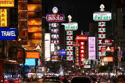 a busy city street at night with many signs at XX GO INN The Grand Palace โกอินน์ พระบรมมหาราชวัง MRT สามยอด in Bangkok