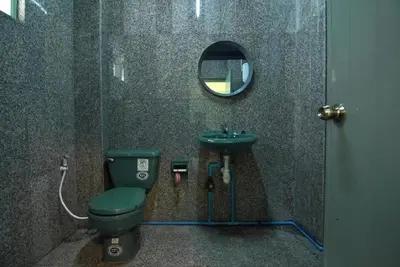 a bathroom with a green toilet and a sink at XX GO INN The Grand Palace โกอินน์ พระบรมมหาราชวัง MRT สามยอด in Bangkok