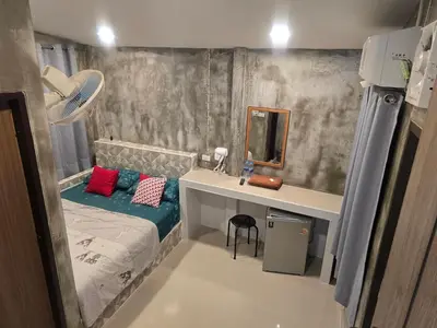 a bedroom with a bed and a desk with a mirror at Gail's Hostels in Bangkok