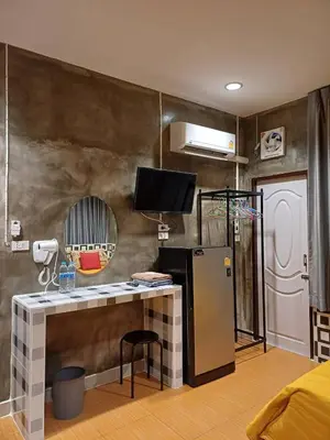 a room with a desk with a tv and a refrigerator at Gail's Hostels in Bangkok