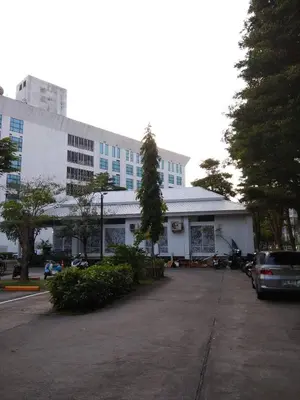 a white building with a car parked in a parking lot at Savi Rooms Premium 1 Near Bkk Piyavet Hospital in Bangkok