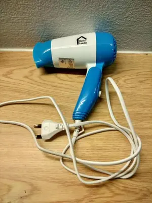 a hair dryer with a cord on a wooden floor at Savi Rooms Premium 1 Near Bkk Piyavet Hospital in Bangkok