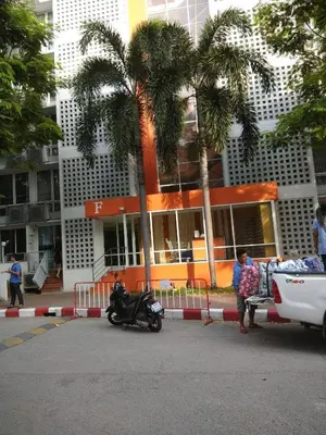 a man is standing next to a truck with a motorcycle at Savi Rooms Deluxe 3 Nr Bangkok piyavet Hospital in Bangkok