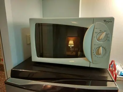 a microwave oven sitting on top of a refrigerator at Savi Rooms Super Deluxe Studio 2 Nr Bkk Hospital in Bangkok