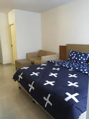 a bedroom with a bed with a blue blanket with white crosses at Savi Rooms Premium studio near bkk Piyavet hospital near most famous pubs in Bangkok