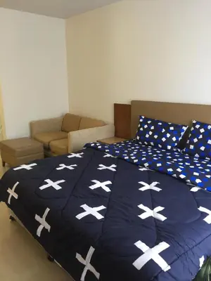 a bed with a blue comforter with white crosses at Savi Rooms Premium studio near bkk Piyavet hospital near most famous pubs in Bangkok
