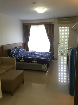 a bedroom with a bed and a couch and a window at Savi Rooms Premium studio near bkk Piyavet hospital near most famous pubs in Bangkok