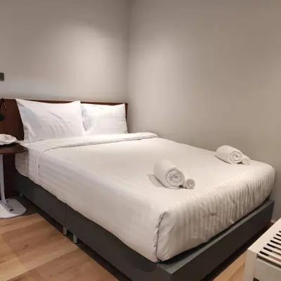 a bedroom with a bed with white sheets and pillows at ROOMS at Number60 Khaosan Bangkok in Bangkok