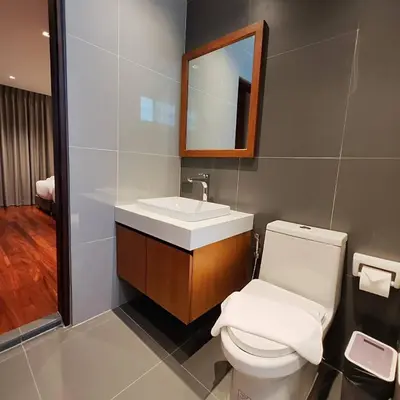 a bathroom with a toilet and a sink and a mirror at ROOMS at Number60 Khaosan Bangkok in Bangkok