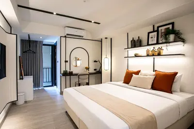 a bedroom with a large white bed and a desk at Pillow B Hotel in Ban Zong Katiam