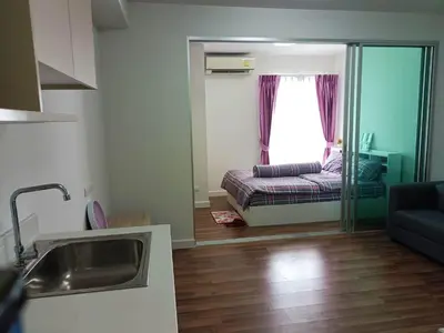 a kitchen and living room with a couch and a window at M Stay in Nonthaburi