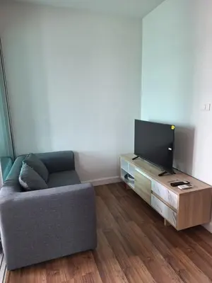 a living room with a couch and a flat screen tv at M Stay in Nonthaburi