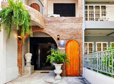 a brick building with a wooden door and plants at Beautiful 3 Bedroom Baroque House near Asoke BTS in Bangkok