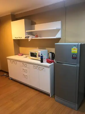 a small kitchen with a refrigerator and a microwave at Regent Srinakarin18 in Amphoe Phra Khanong