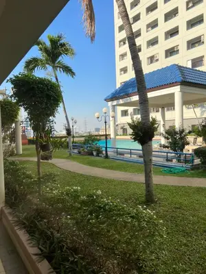a palm tree in a park next to a building at Regent Srinakarin18 in Amphoe Phra Khanong