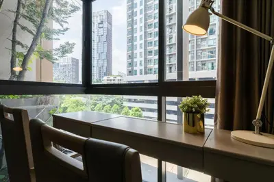 a desk in front of a window with a view of a building at bts thong lor \u6e38\u6cf3\u6c60-\u514d\u8d39\u65e0\u7ebf\u7f51\u7edc in Bang Khen