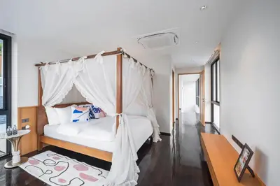 a bedroom with a white bed with a canopy at \u66fc\u8c37\u6cf0\u5883\u5962\u5922\u5225\u5885 in Ban Nong Rong (1)