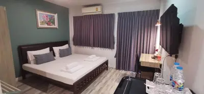a small bedroom with a bed and a desk at Victory Room in Bangkok