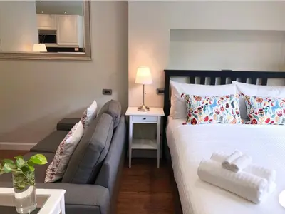 a bedroom with a bed and a couch and a mirror at The Residences at C&C in Bangkok