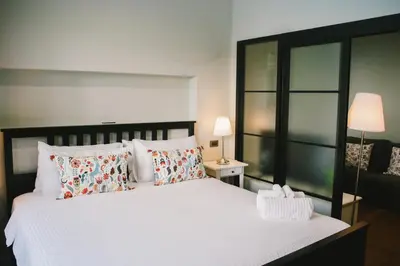 a bedroom with a large white bed with pillows at The Residences at C&C in Bangkok