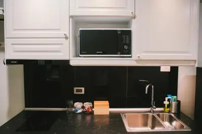 a kitchen with a sink and a microwave at The Residences at C&C in Bangkok