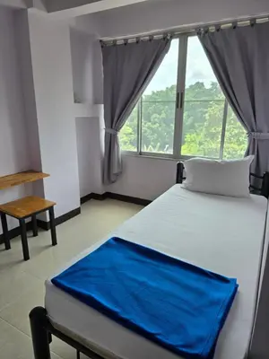 a bedroom with a bed with a blue blanket on it at Bella Bella Riverview in Bangkok