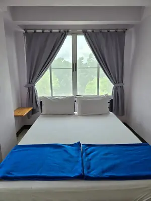 a bed in a room with a large window at Bella Bella Riverview in Bangkok