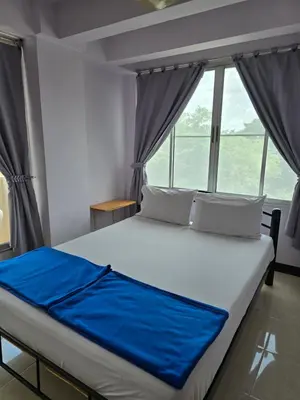 a bed in a room with a large window at Bella Bella Riverview in Bangkok