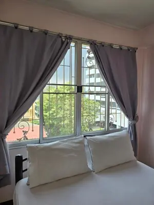 a bed in front of a large window at Bella Bella Riverview in Bangkok