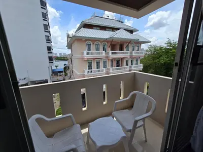 a balcony with two chairs and a building at Bella Bella Riverview in Bangkok