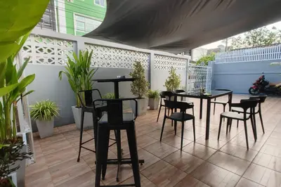 a patio with black tables and chairs and plants at \u66fc\u8c37\u8f89\u714c \u65fa\u4e2d\u5e26\u9759 \u5e26\u5ead\u9662\u76843\u4e2a\u623f\u95f4\u72ec\u7acb\u522b\u5885 \u9884\u8ba25\u5929\u4ee5\u4e0a\u63d0\u4f9b\u514d\u8d39\u63a5\u673a\u4e00\u6b21 in Bang Rak