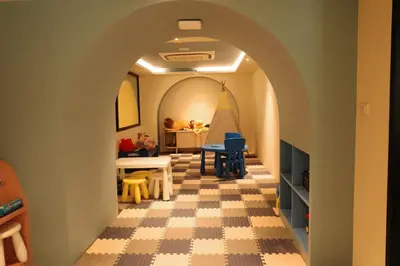a room with a hallway with a table and chairs at Kastel Bangkok Hotel in Bangkok