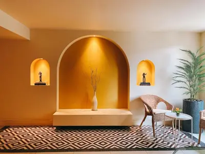 a room with a table and chairs and a vase at Kastel Bangkok Hotel in Bangkok