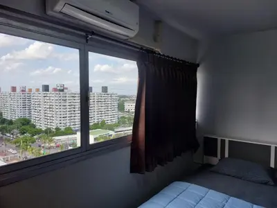 a bedroom with a window with a view of a building at Solitude Skies14th Floor Studio in Nonthaburi