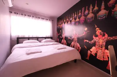 a bedroom with two beds and a wall with a poster at Everyday Bangkok Hostel in Bangkok