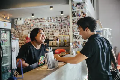 a man sitting at a bar talking to a woman at Everyday Bangkok Hostel in Bangkok