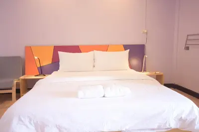 a bedroom with a white bed with two towels on it at Room@Vipa in Bangkok