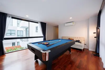 a living room with a pool table and a couch at \u66fc\u8c37\u5e02\u4e2d\u5fc3\u4e03\u5367\u5ba4\u72ec\u680b\u8c6a\u534e\u6cf3\u6c60\u522b\u5885 in Bangkok