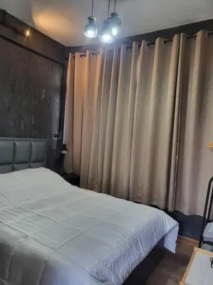 a bedroom with a white bed and curtains at auntythong house in Bangkok
