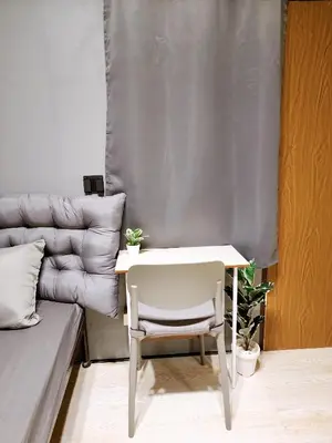 a white table and chair next to a couch at 110-Olan Place Homely room Free Wi-Fi and Near BTS line in Bangkok