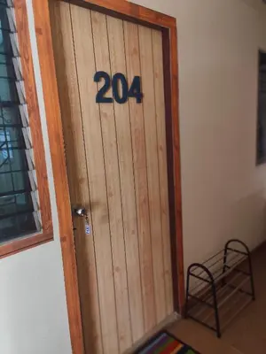 a wooden door with the on it at J Place Studio 204 with nice fan free Wifi, near Skytrain in Bangkok