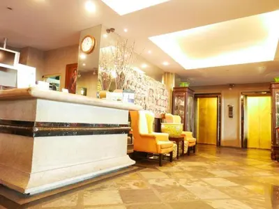 a lobby with a bar with chairs and a clock at Best Comfort Bangkok Hotel in Bangkok