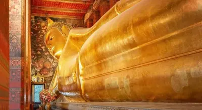 a gold statue in a room with a painting at Assembly Hostel in Bangkok
