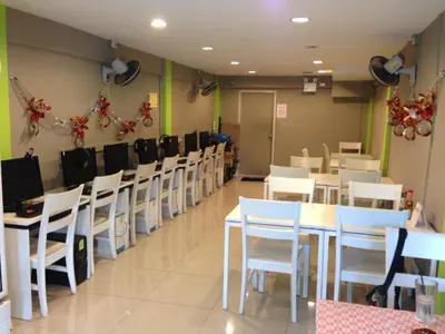 a dining room with white tables and white chairs at Ipremium Sukhumvit 81 Hotel in Bangkok
