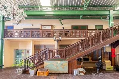 a large wooden staircase in a building with a chandelier at Art Hotel Sanamchai in Bangkok