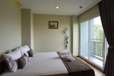a bedroom with a bed with a large window at Home Inn Hotel in Bangkok
